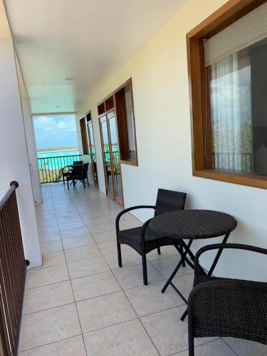 a room with chairs and tables and a view of the ocean at Best Western Grand Baymen Gardens in San Pedro