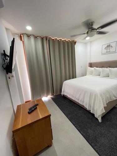 a bedroom with a bed and a television in it at Best Western Grand Baymen Gardens in San Pedro