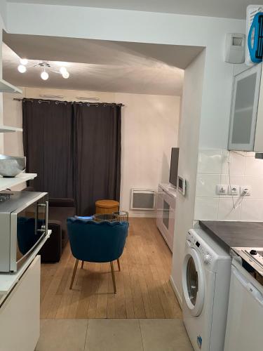 une cuisine avec un lave-linge et une chaise bleue dans l'établissement Appartement proche de paris, à Saint-Cloud