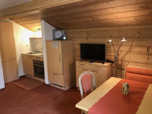 eine Küche mit Holzwänden und einen TV im Zimmer in der Unterkunft Gästehaus Koch in Berwang