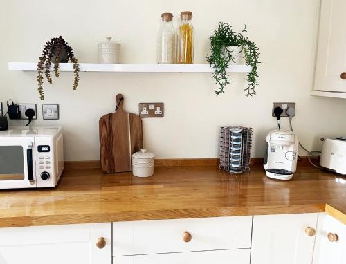 a kitchen with a counter top with a microwave at Traditional 2 bedroom Cottage in Stratford-upon-Avon