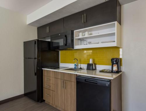 a kitchen with black appliances and a black refrigerator at MainStay Suites Savannah Midtown in Savannah