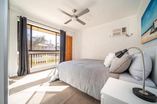 a bedroom with a bed and a large window at Serenity by the Sea Grange in Grange