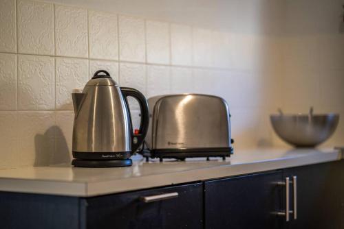 a tea kettle and toaster on a kitchen counter at Serenity by the Sea Grange in Grange