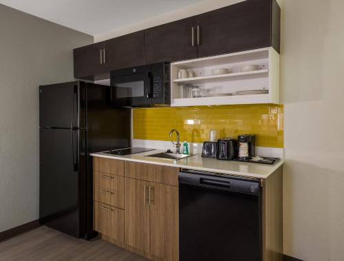 a kitchen with black appliances and a black refrigerator at MainStay Suites Savannah Midtown in Savannah