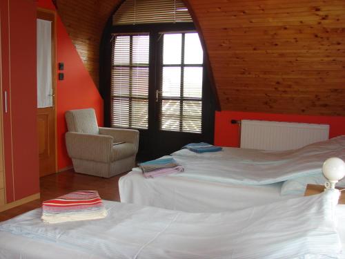 a bedroom with two beds and a chair in it at Napfény villa in Balatonfüred