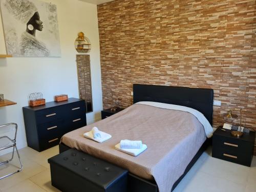 a bedroom with a bed and a brick wall at Appartamento del Li-Lioni di Teranga 2 in Platamona