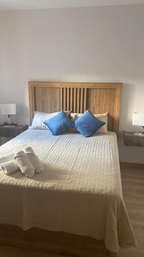 a bedroom with a large bed with blue pillows at Edulis 2 in Arenas de San Pedro