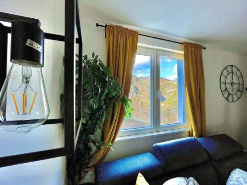 a living room with a blue couch and a window at VILA MASLACAK in Popovići