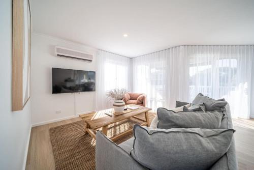 a living room with two chairs and a table at Casa Del Sol Aldinga Beach in Aldinga Beach