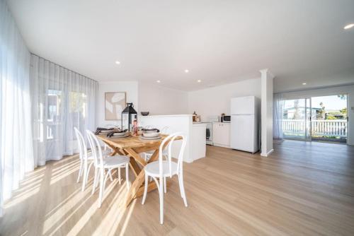 a kitchen and dining room with a table and chairs at Casa Del Sol Aldinga Beach in Aldinga Beach