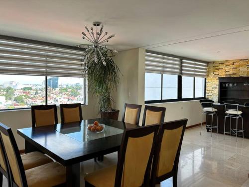 a dining room with a table and chairs and a kitchen at PENTHOUSE de lujo en las animas! A 5 minutos de plaza Angelópolis in El Gallinero