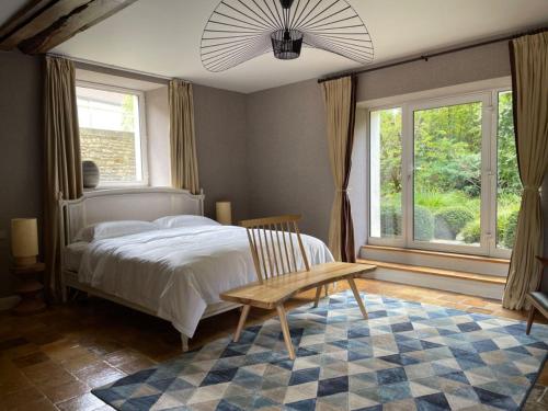 a bedroom with a bed and a table and windows at Dipper star in Thoiry