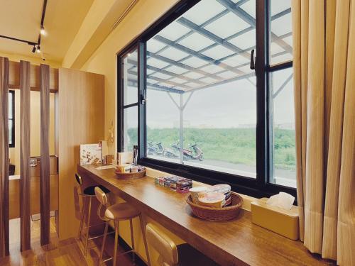 Baishaにある漫活時光民宿 Leisure Livingのカウンターと大きな窓が備わる客室です。