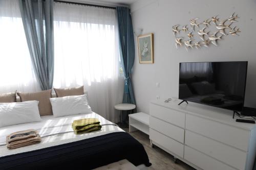 a bedroom with a bed with a dresser and a television at El Angel by Ntinos in Kremasti