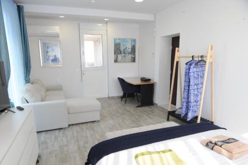a bedroom with a bed and a couch and a desk at El Angel by Ntinos in Kremasti