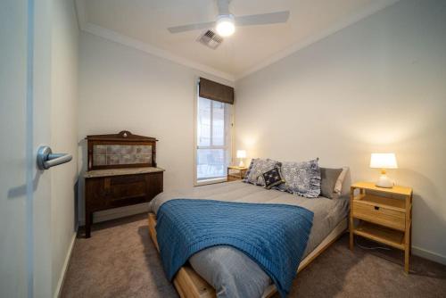 - une chambre avec un lit doté d'une couverture bleue et d'une fenêtre dans l'établissement The Arlington West Hindmarsh, à Bowden