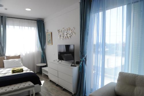 a bedroom with a bed and a tv and curtains at El Angel by Ntinos in Kremasti