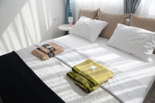 a white bed with towels and pillows on it at El Angel by Ntinos in Kremasti