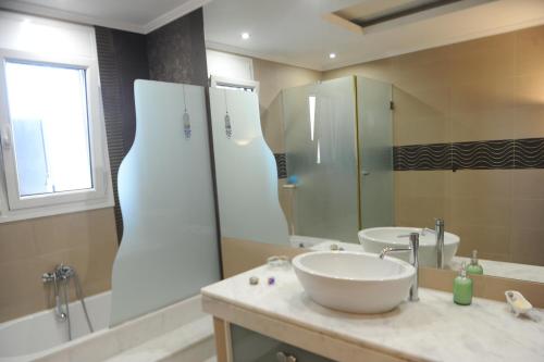 a bathroom with two sinks and a large mirror at El Angel by Ntinos in Kremasti