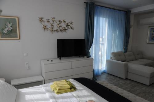 a bedroom with a bed and a tv and a couch at El Angel by Ntinos in Kremasti