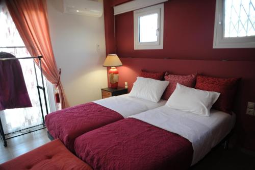 a bedroom with a large bed with red walls at El Angel by Ntinos in Kremasti