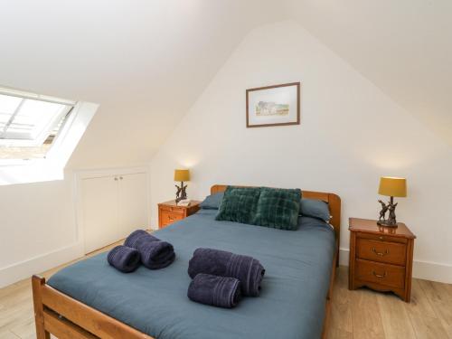 Un dormitorio con una cama con almohadas moradas y una ventana en The Old Stable, en Witney
