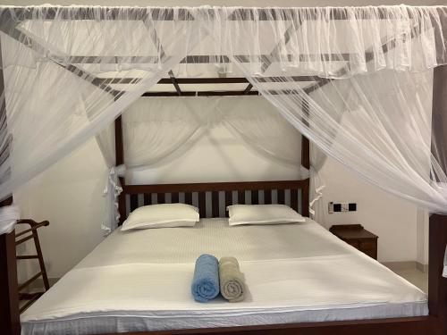 a bed with two pairs of sandals sitting on it at Awesome Guest Mirissa in Mirissa
