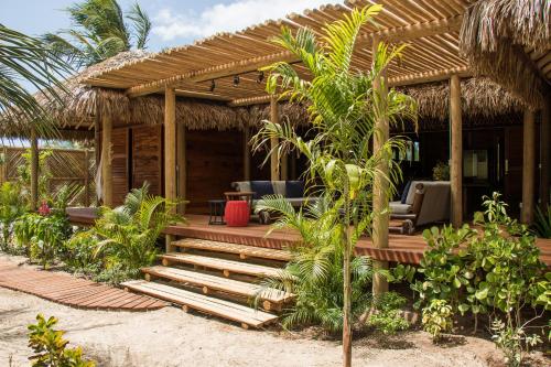 ein Haus am Strand mit einer Holzveranda in der Unterkunft Rancho do Kite Villas in Prea