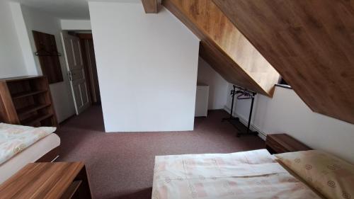 a small room with two beds and an attic at Hotel Hubert in Hřensko