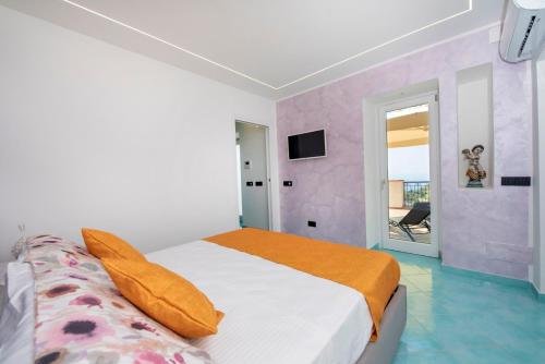 een slaapkamer met een groot bed en een oranje deken bij La Maison Raffaele & Rita in Amalfi