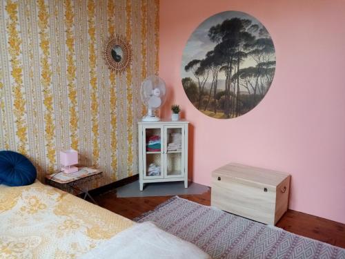 1 dormitorio con 2 camas y reloj en la pared en Les Toiles du Figuier, en Espéraza