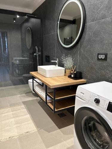 a bathroom with a sink and a washing machine at V Residence Apartments in Rabac