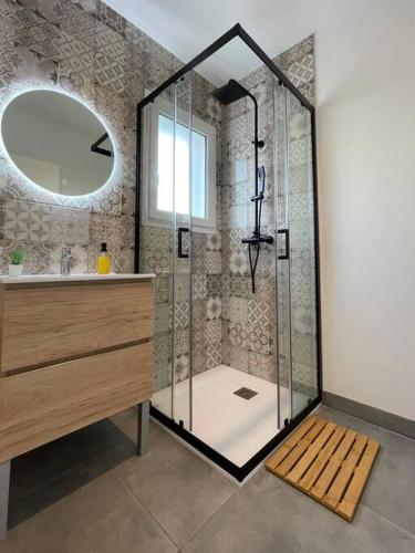 une salle de bain avec une douche avec un lavabo et un miroir dans l'établissement Maison neuve à 25mn de l'Océan, à Taller
