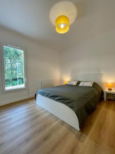 une chambre avec un grand lit et une fenêtre dans l'établissement Maison neuve à 25mn de l'Océan, à Taller