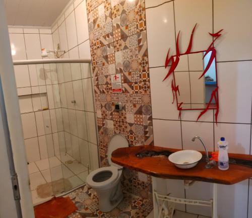 een badkamer met een toilet en een douche met rode graffiti bij Rancho Andrade in Três Marias