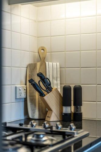 a kitchen counter with a knife block next to a stove at The North Star City View Jacuzzi Sauna in Adelaide