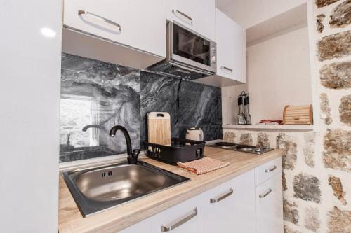 a kitchen with a sink and a counter at Apartments Florian in Lopud Island