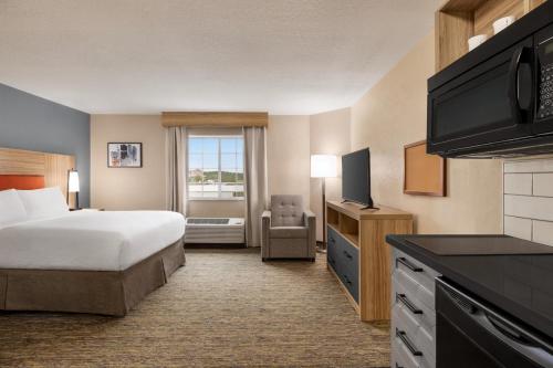 a hotel room with a bed and a television at Candlewood Suites-Augusta, an IHG Hotel in Augusta
