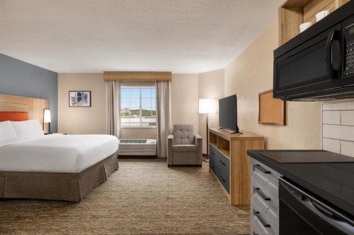 a hotel room with a bed and a television at Candlewood Suites-Augusta by IHG in Augusta