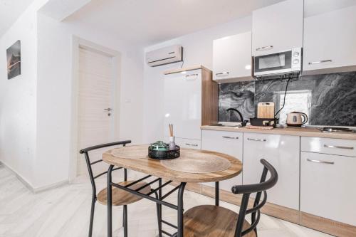 a kitchen with a wooden table and two chairs at Apartments Florian in Lopud Island