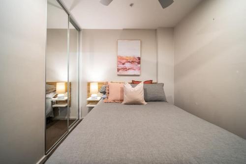 Dormitorio pequeño con cama y espejo en Huttside Luxury Central Secure Car park, en Adelaida