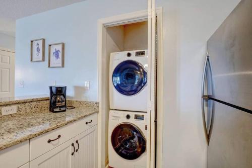 a kitchen with a washer and dryer next to a refrigerator at Oceanview Resort*Hot tub*North Topsail Beach in North Topsail Beach