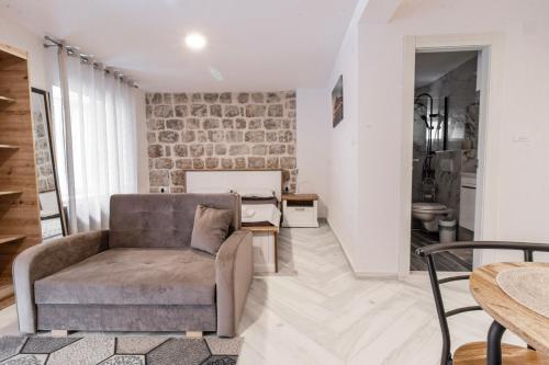 a living room with a couch and a brick wall at Apartments Florian in Lopud Island