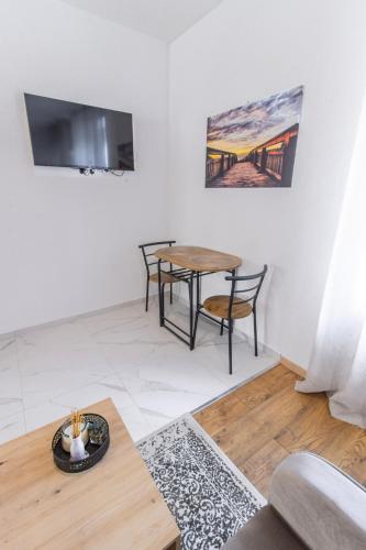 a living room with a table and chairs and a tv at Apartments Florian in Lopud Island