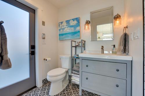 a bathroom with a toilet and a sink and a mirror at Luxe, Modern Studio with Sweeping City Views! in Boise