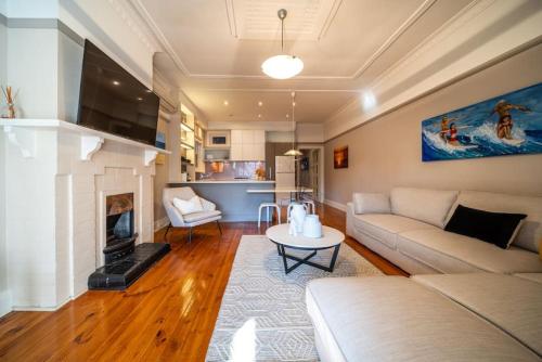 a living room with a couch and a fireplace at The Fourth Sussex House in Glenelg
