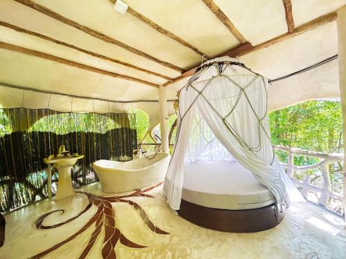 ein Schlafzimmer mit einem Bett und einer Badewanne in einem Zimmer in der Unterkunft Ikalar in Akumal