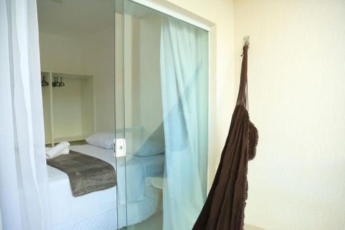 a room with a glass door with a bed and a mirror at Casa a 560 metros da Praia de Ponta Negra in Natal