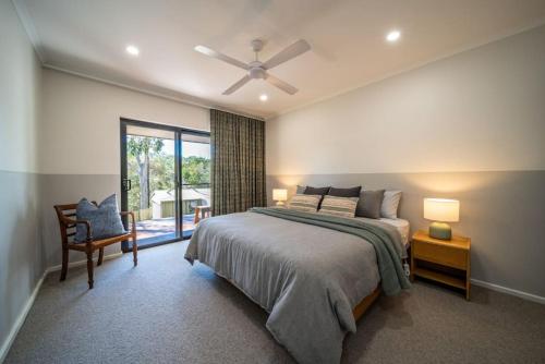 Adelaide Hills Retreat - Surrounded by Nature في Ironbank: غرفة نوم بسرير ومروحة سقف